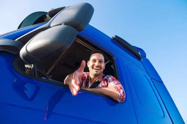 truck driver leaning out of his trucking looking for a handshake for his invoice factoring rates